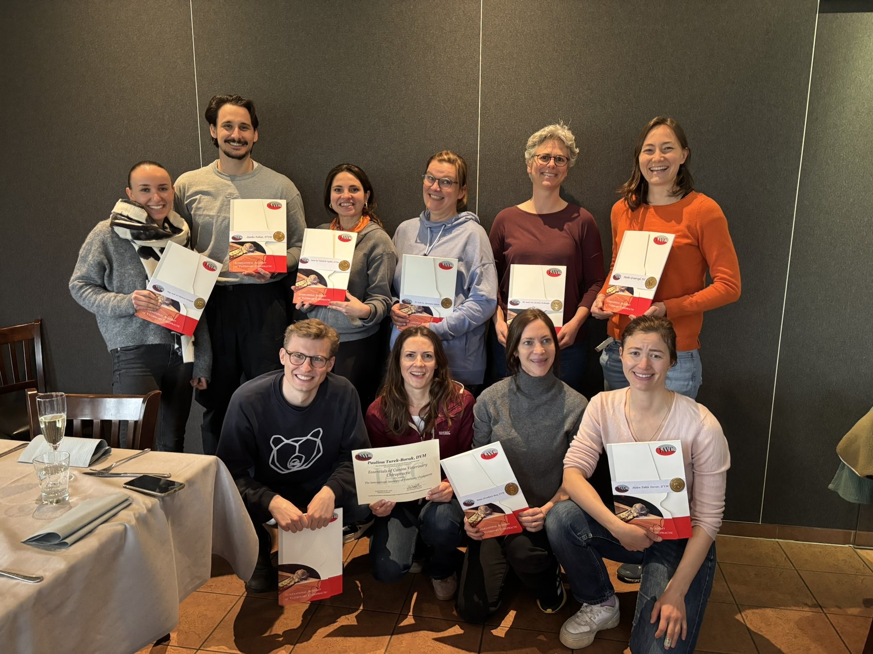 Canine Essentials participants holding completion folders and certificates.
